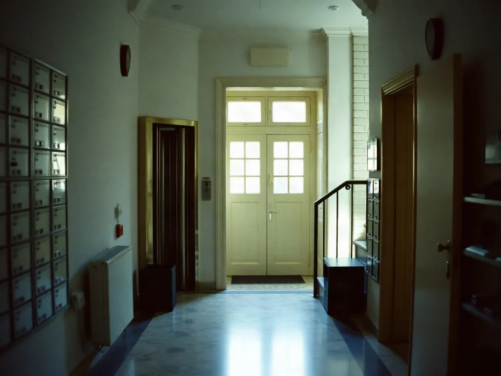 L’androne di un condominio con le cassette della posta e il pavimento in marmo